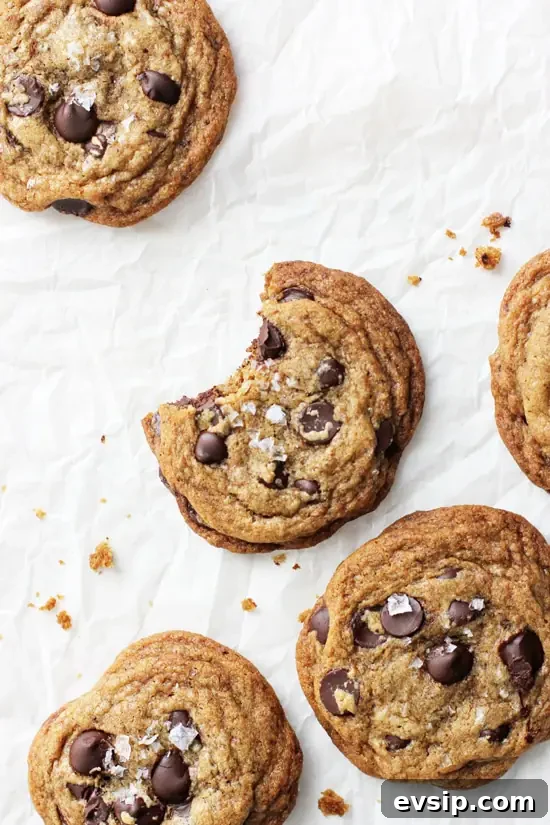 Espresso Chocolate Chip Cookies on parchment with a bite taken out of one.