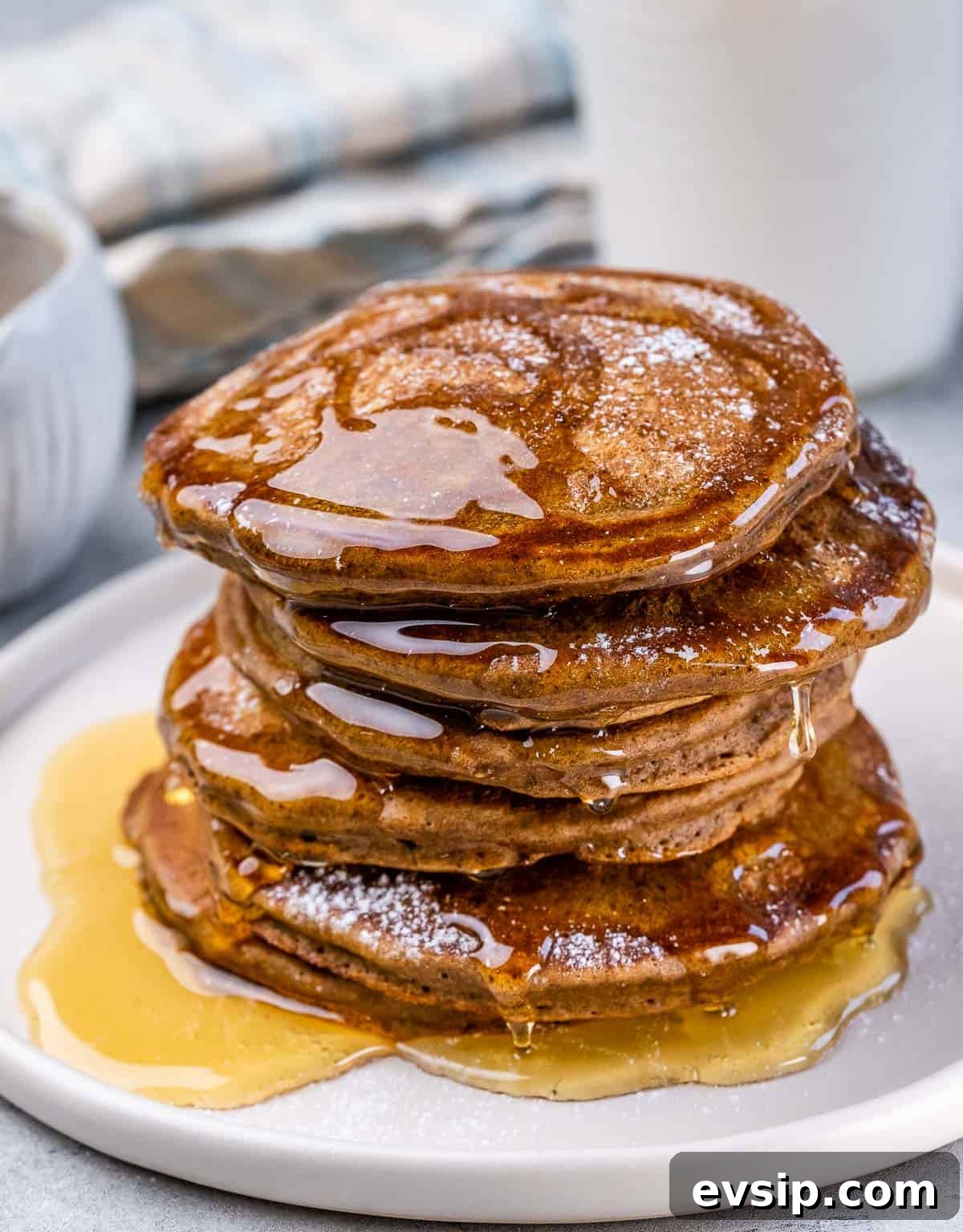 Stack of gingerbread pancakes drizzled with honey on a plate. 