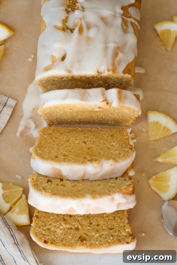 lemon loaf with glaze sliced on brown parchment paper