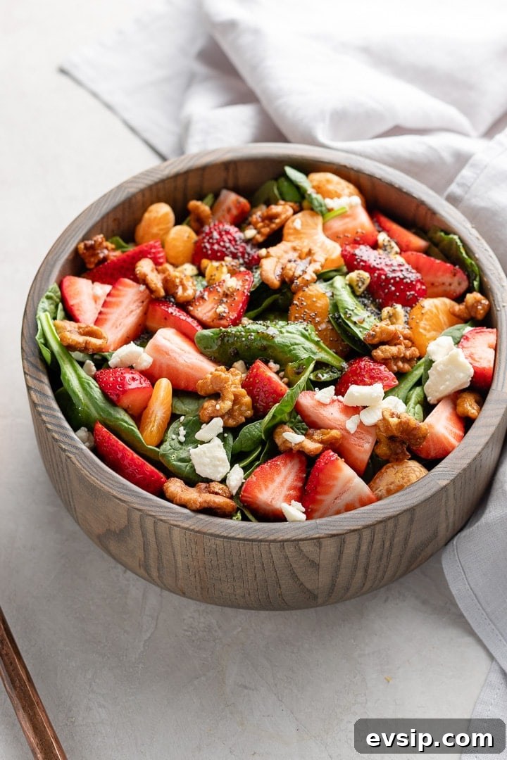 Close up of strawberry spinach salad in a bowl, ready to toss and serve.