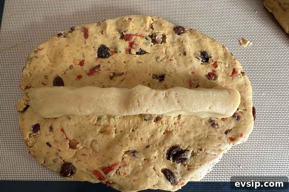 Light and Fluffy Gluten-Free Stollen Recipe for Holidays 8 The dough pressed in an oval with a strip of almond paste in the middle.