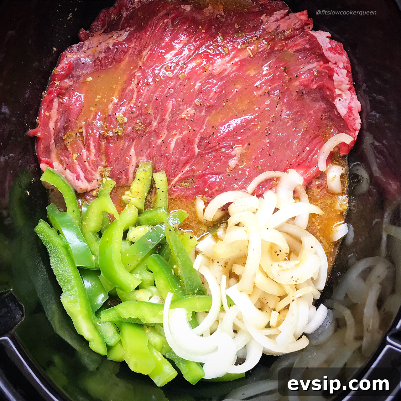 overhead shot of uncooked cilantro lime beef in a black slow cooker