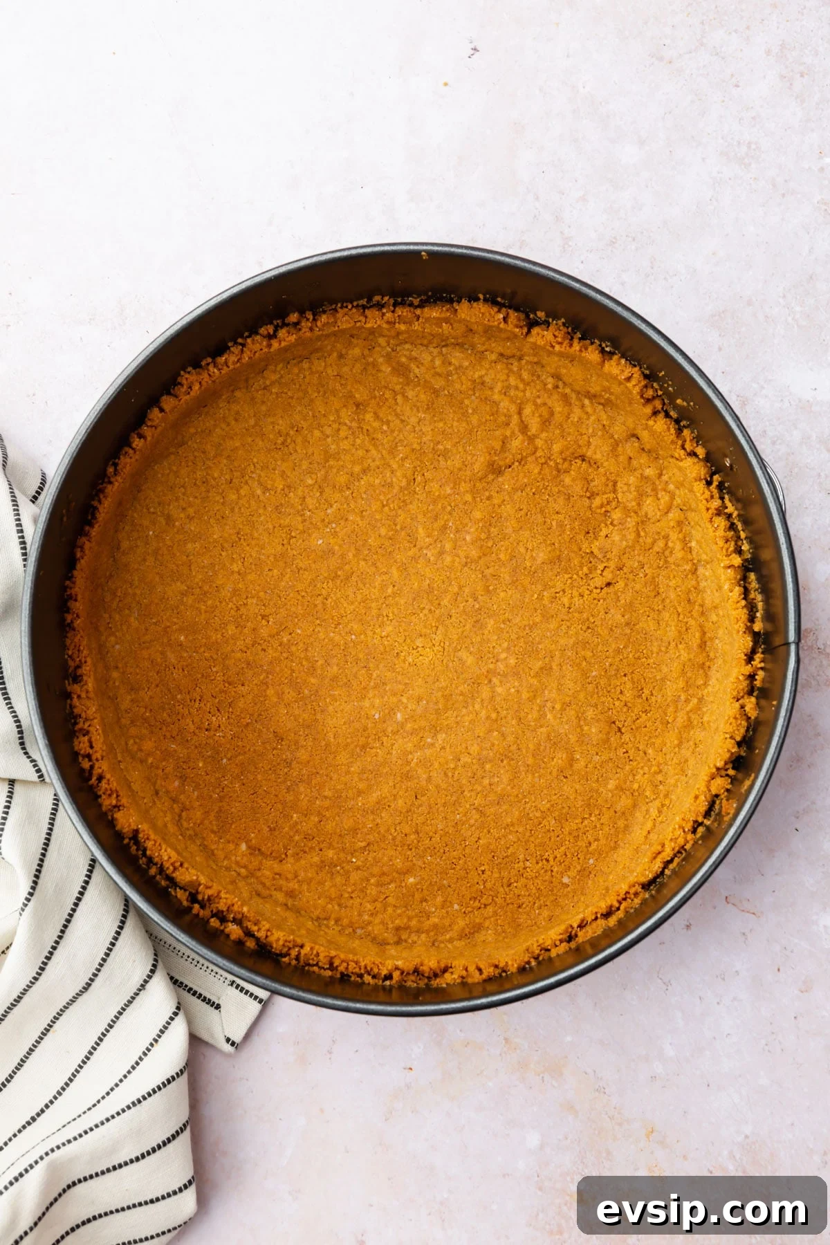 Baked gluten-free graham cracker crust in a springform pan.