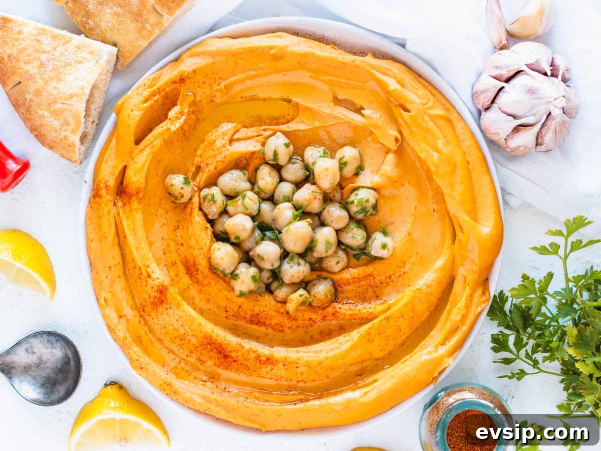 roasted pepper hummus with chickpeas and fresh parsley on top