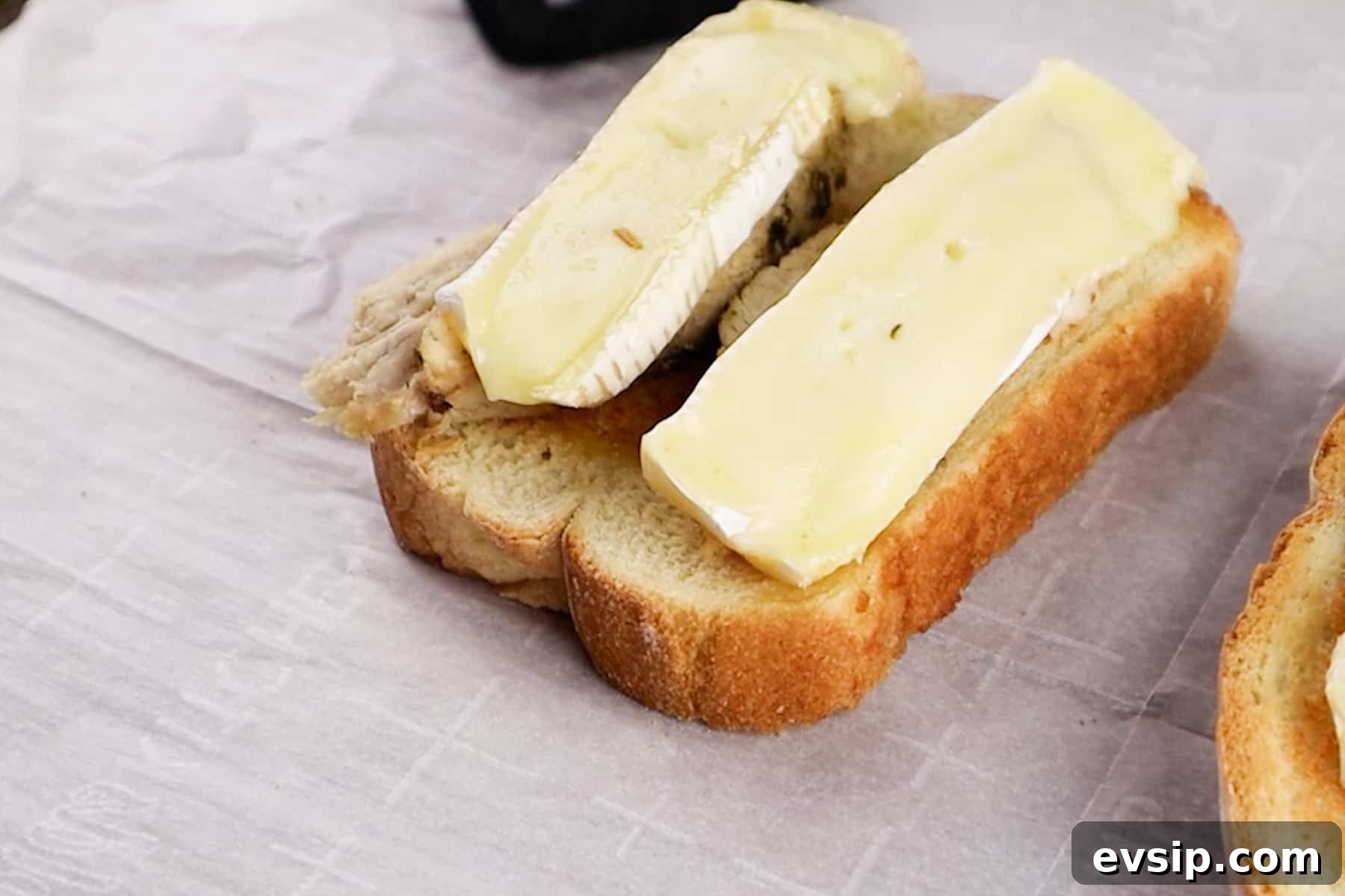Melted brie cheese on top of a turkey sandwich.
