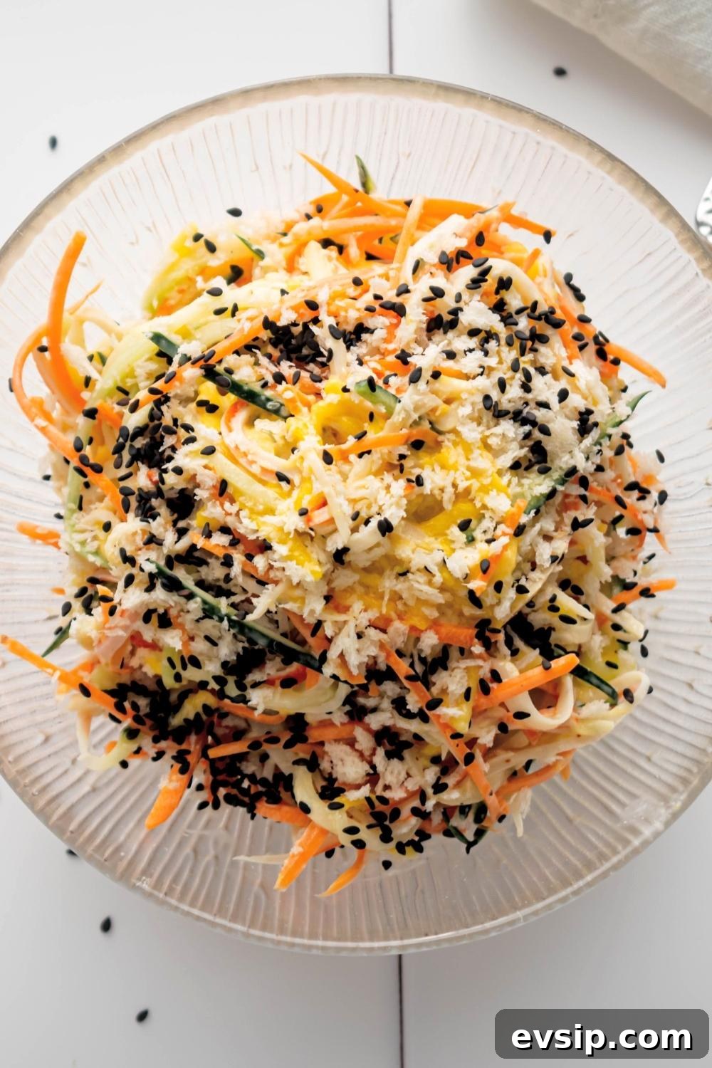 Kani salad in a glass bowl on a white tile counter.