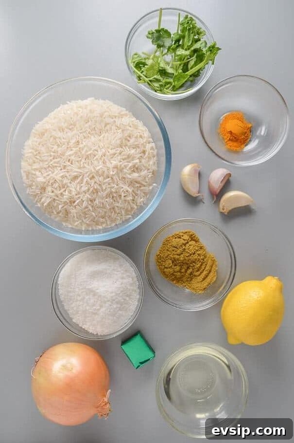 A lemon, an onion, garlic, bowls of rice, desiccated coconut, cilantro, turmeric and oil