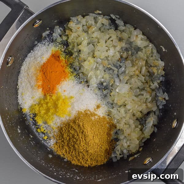 Fried onions, ground coriander and turmeric, lemon rind and desiccated coconut frying in a black pot