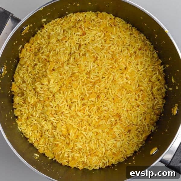 Yellow rice and onions in a black pot