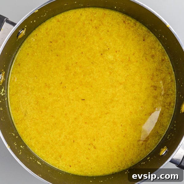 Very yellow liquid and rice in a black pot