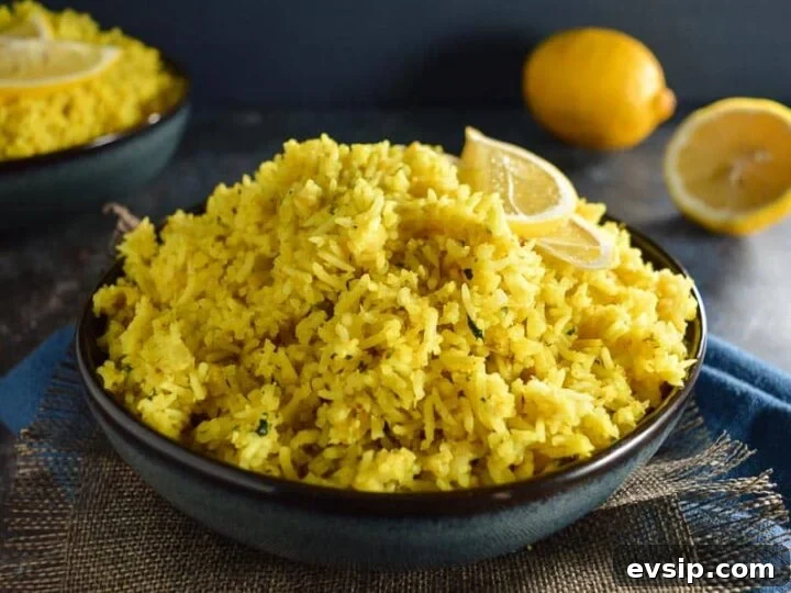 A dark blue bowl of yellow rice with 2 lemon slice halves