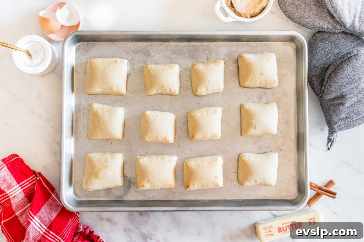 baked square shaped dinner rolls on a baking sheet