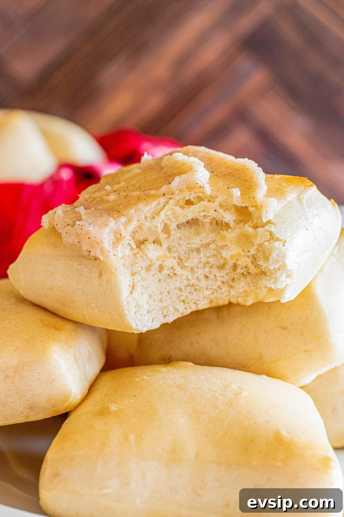 Close up photo of a Texas Roadhouse Roll topped with butter with a bite taken out