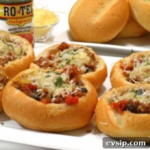 bread bowls filled with sausage and parmesan on a plate.