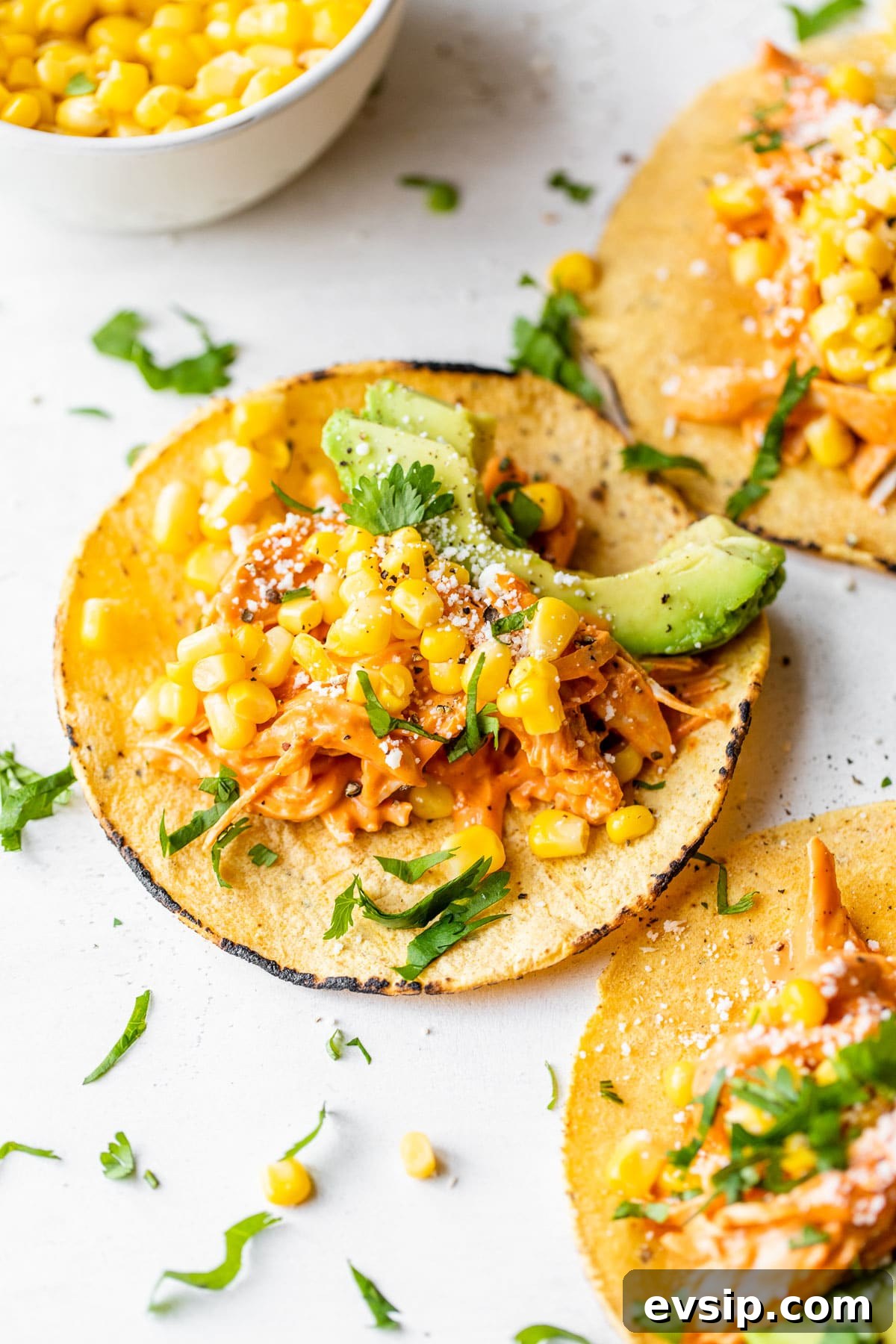 Smoky Chipotle Shredded Chicken Tacos with Creamy Slaw 5 tacos topped with chicken, corn and avocado