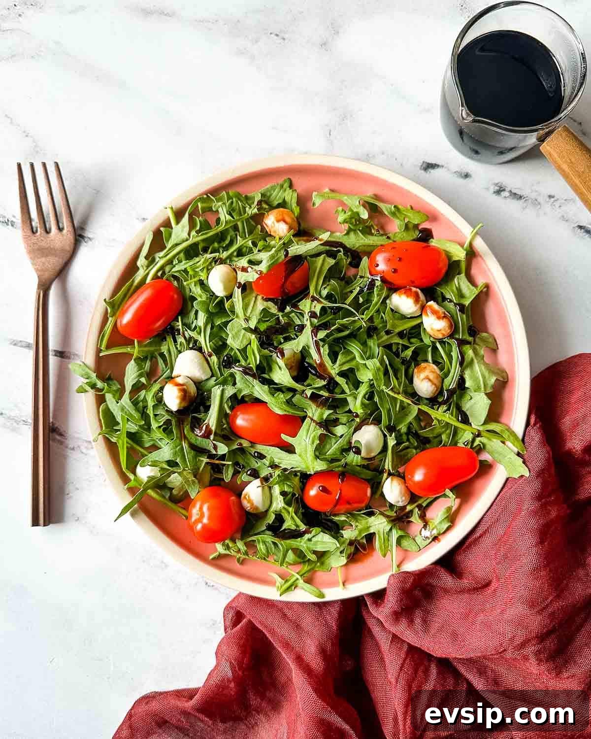 How to Make a Rich Balsamic Reduction for Glazes and Drizzles 2 Balsamic reduction is shown drizzled over a caprese salad with arugula.