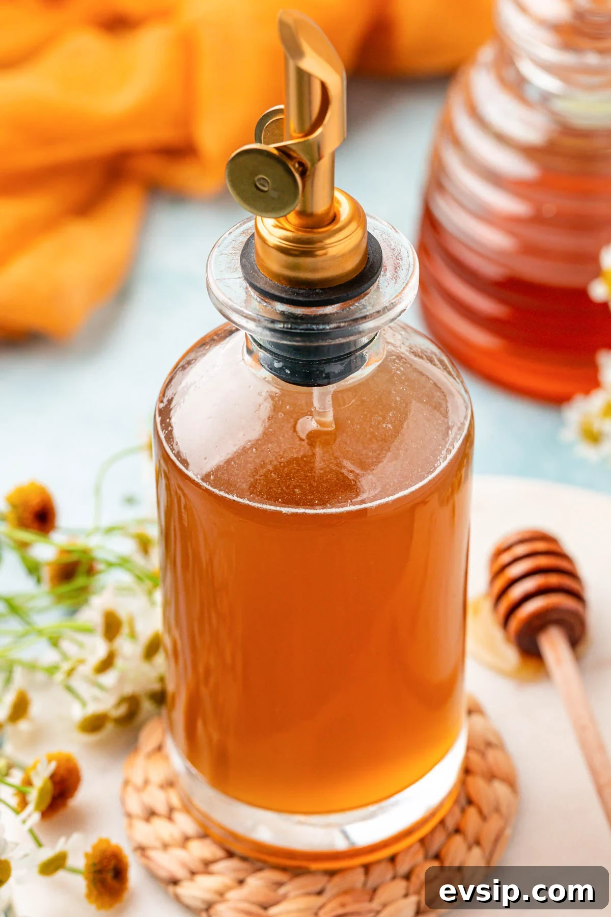 A bottle of honey simple syrup on a table.