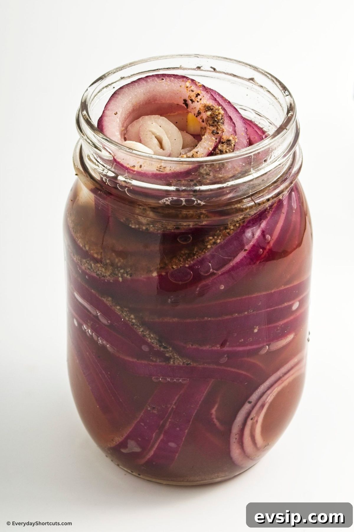 Tangy Quick-Pickled Red Onions for Salads and Sandwiches 7 pickling mixture in a jar with onions