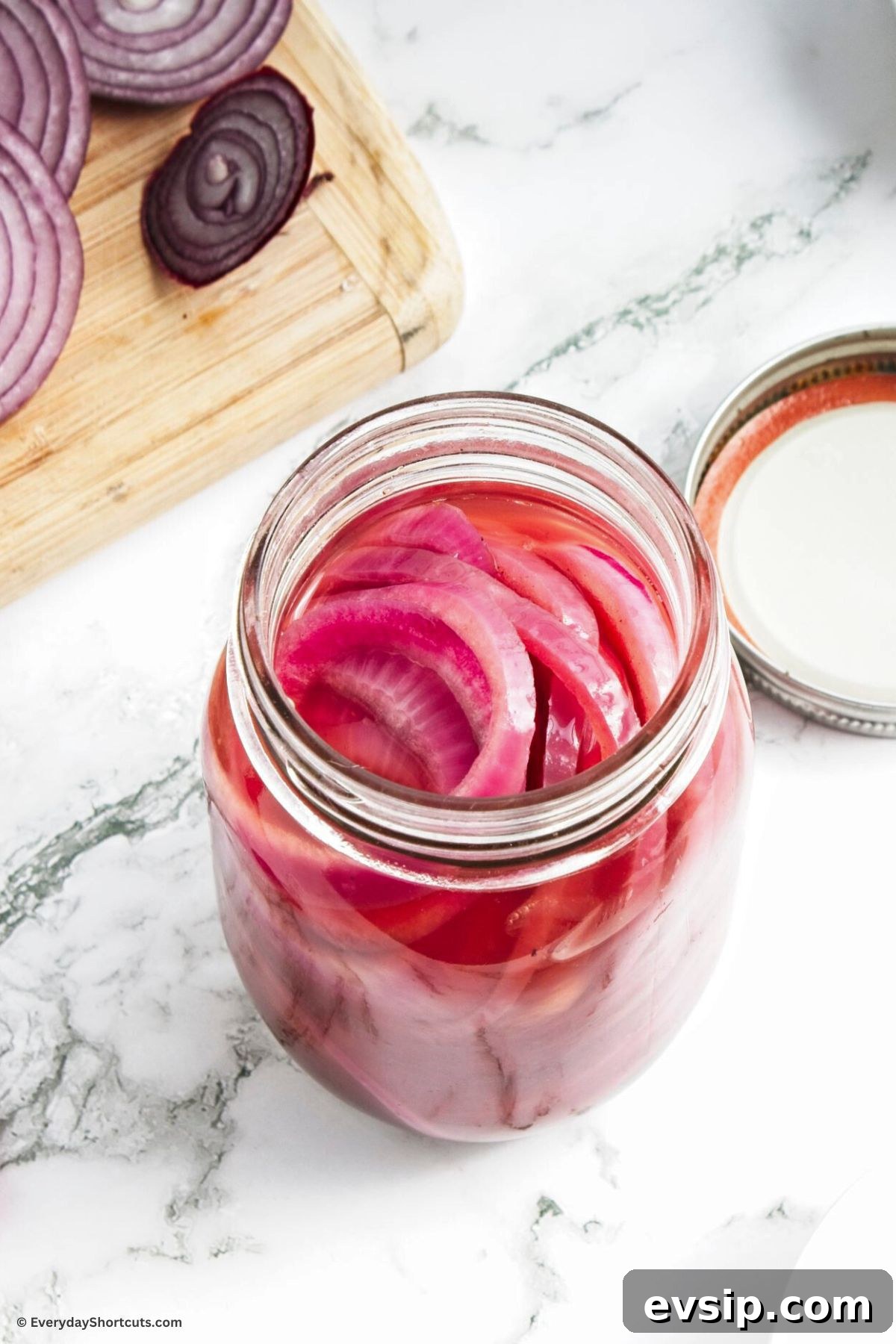 Tangy Quick-Pickled Red Onions for Salads and Sandwiches 8 onions marinated with pickling mixture in a jar