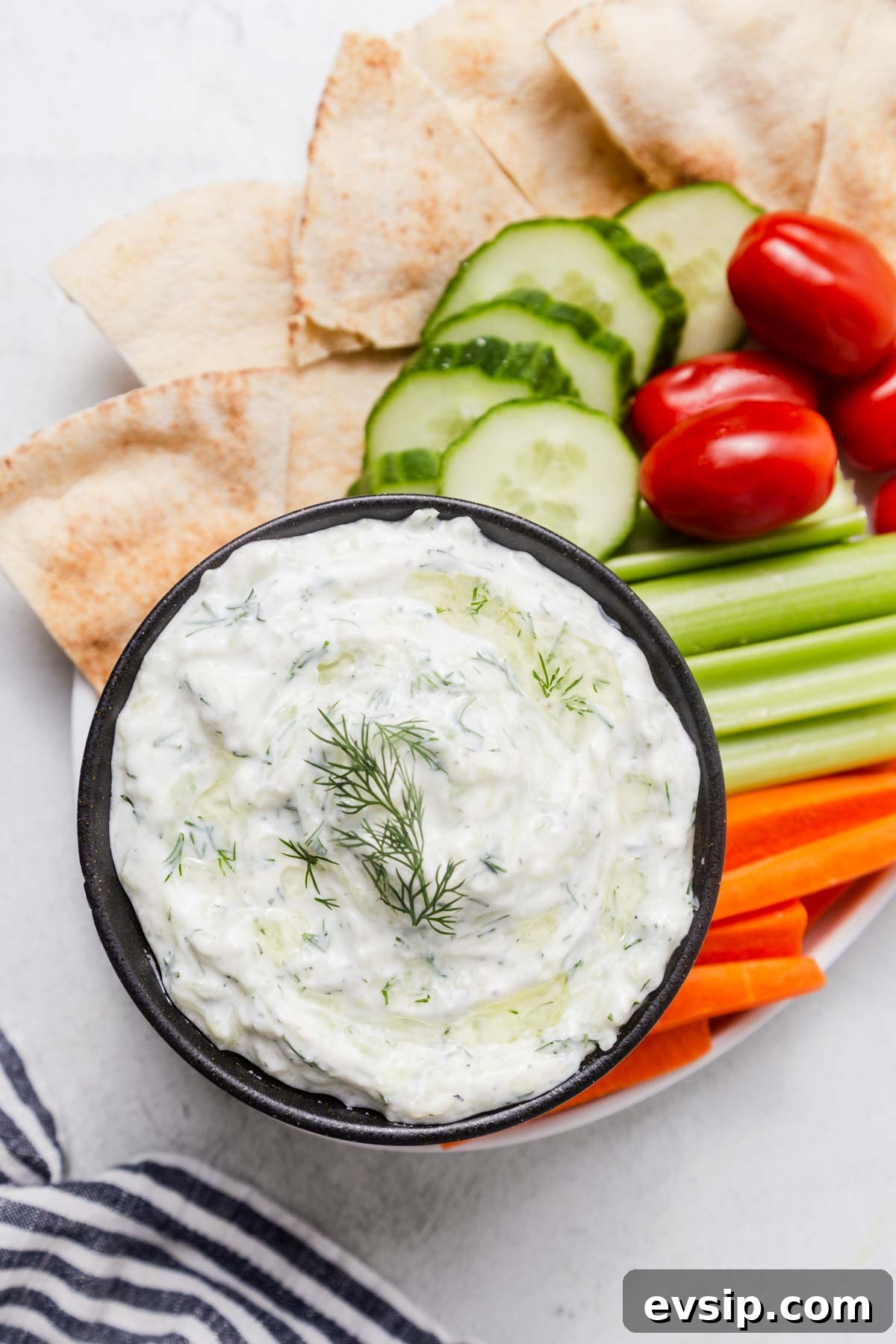 tzatziki dip with pita chips and vegetables.