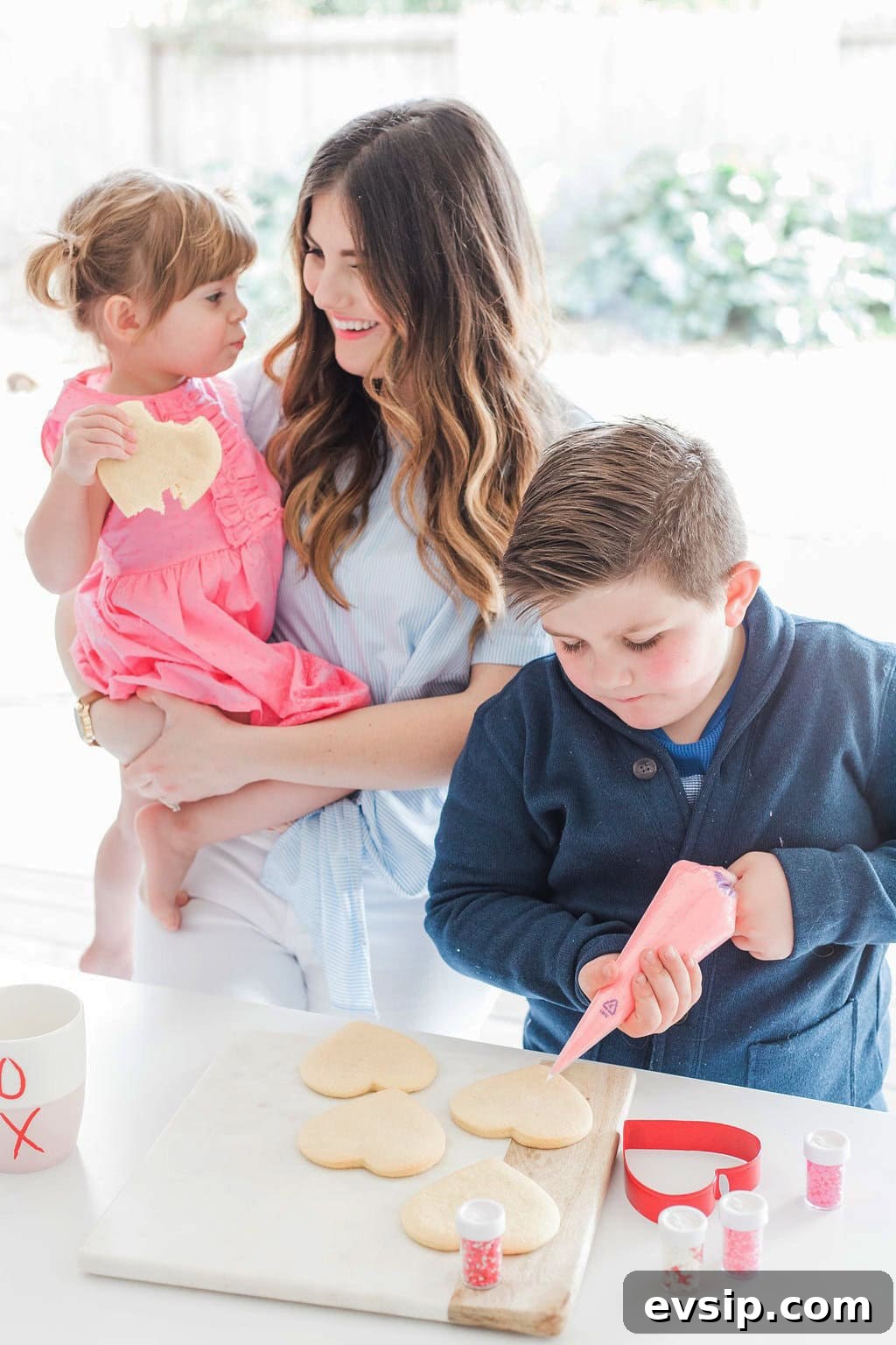 Mom and children decorating cookies. 