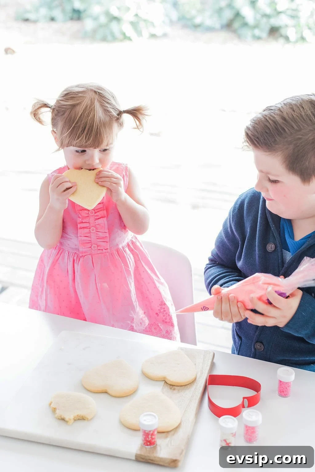 Two small children decorating cookies. 