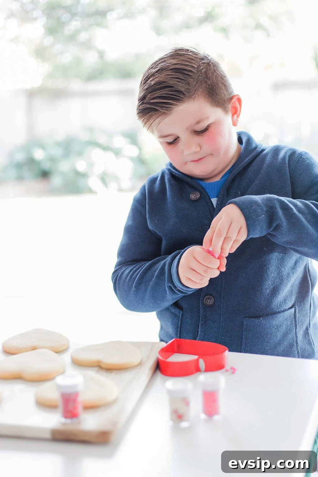 A small boy decorating cookies. 