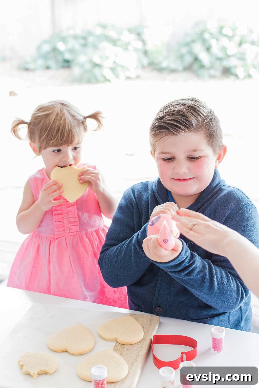 Two small children decorating cookies. 