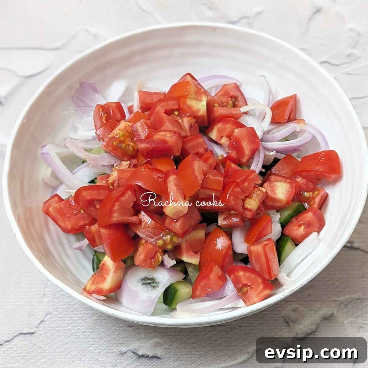 Mediterranean Cucumber and Tomato Salad Recipe for Summer 7 Diced tomato, cucumber and onion in a bowl.