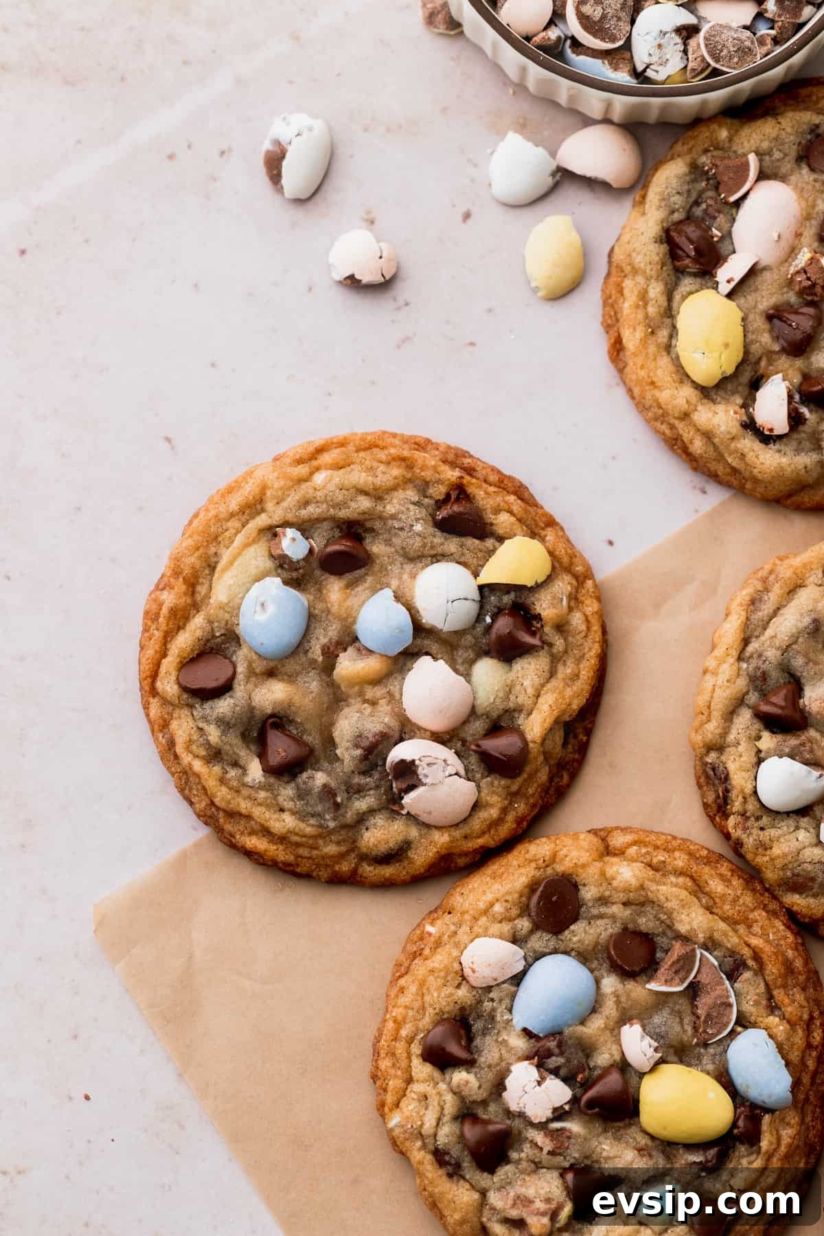Bite-Sized Mini Egg Cookies with Chocolate Candy Centers 2 Mini egg cookies on parchment paper.