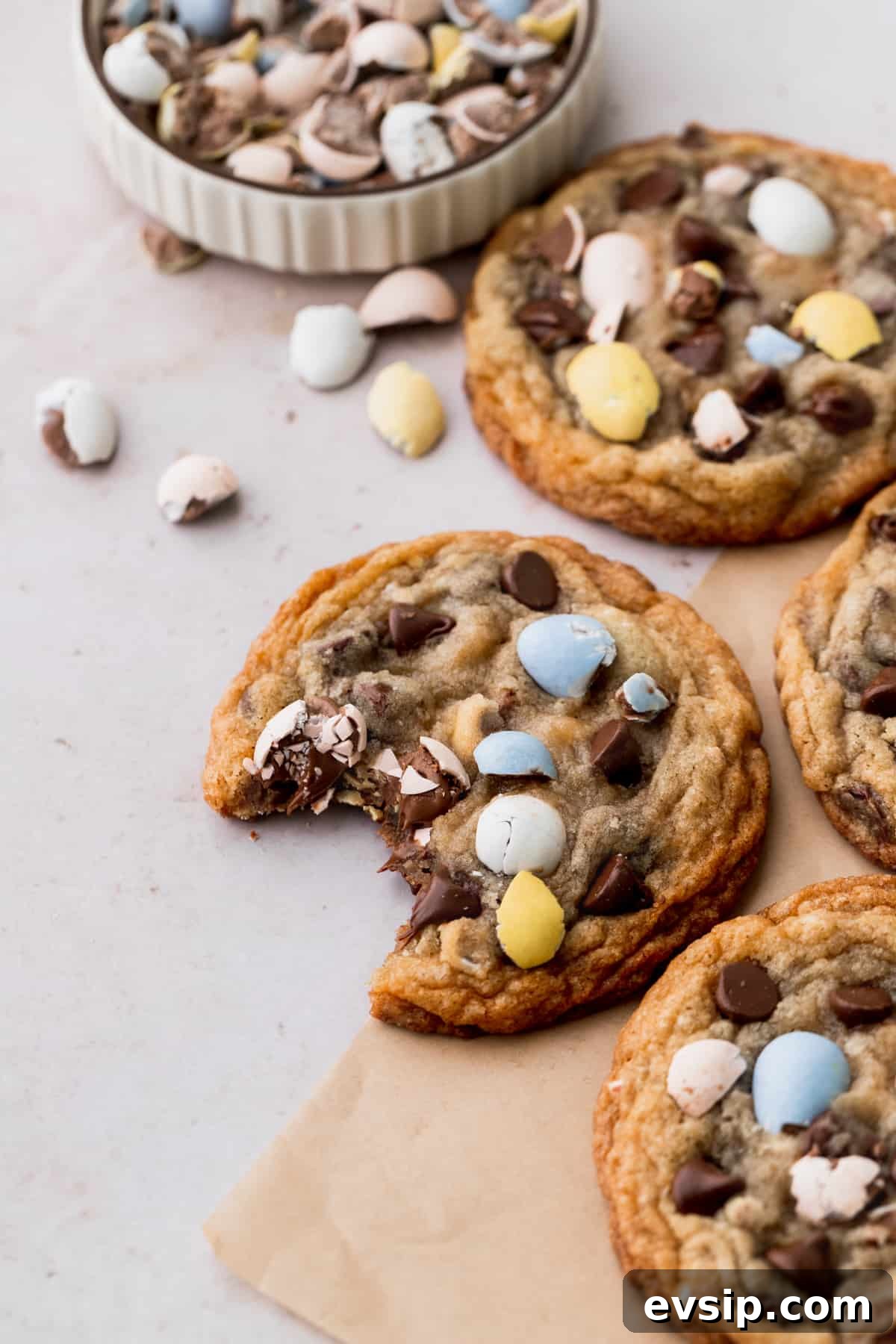 Bite-Sized Mini Egg Cookies with Chocolate Candy Centers 3 A bite missing from the cookie on parchment paper.