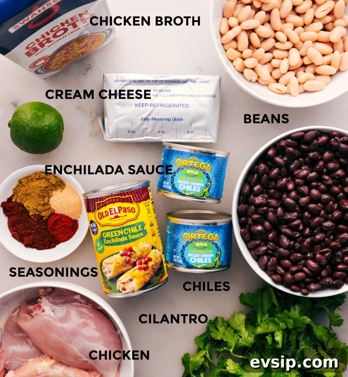 Preparing a Meal: Pouring Ingredients into Slow Cooker This recipe's ingredients are prepped for easy assembly: beans, meat, chiles, sauce, seasonings, cream cheese, lime, and cilantro.