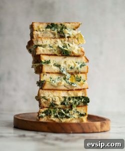 Spinach Artichoke Grilled Cheese 6 sandwich halves stacked on each other with filling dripping out
