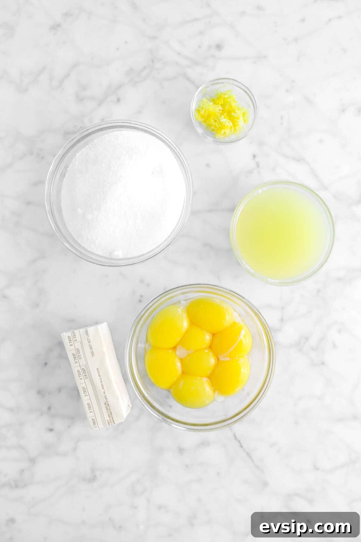 lemon zest, sugar, lemon juice, egg yolks, butter on marble counter