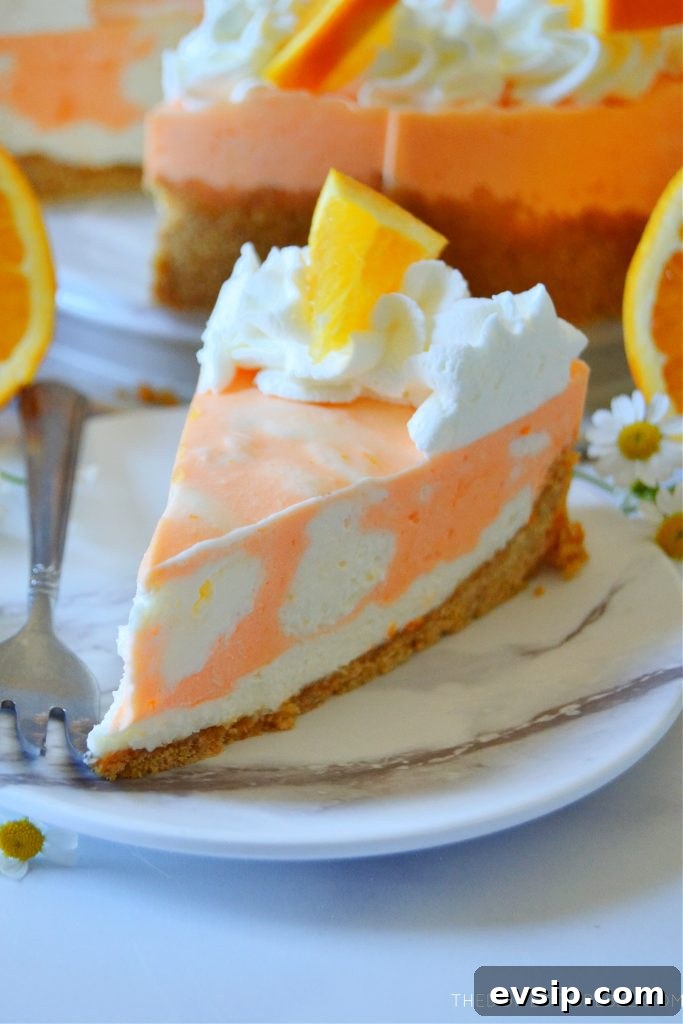 No-Bake Orange Creamsicle Cheesecake Recipe 8 closeup of a slice of orange creamsicle cheesecake on a white marble plate