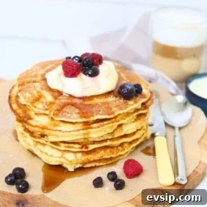 20 Sourdough Discard Recipes Perfect for Freezing 17 A stack of sourdough discard pancakes topped with whipped cream and berries and drizzled in maple syrup.
