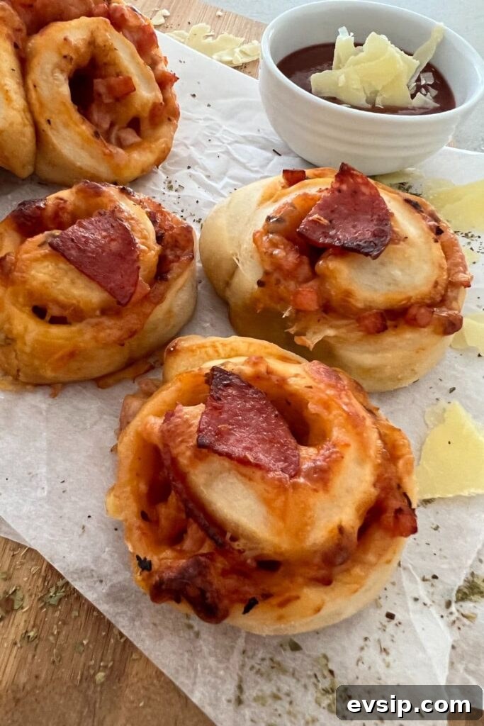 20 Sourdough Discard Recipes Perfect for Freezing 7 3 sourdough pizza rolls that have been baked and are displayed with a dish of homemade tomato pizza sauce.