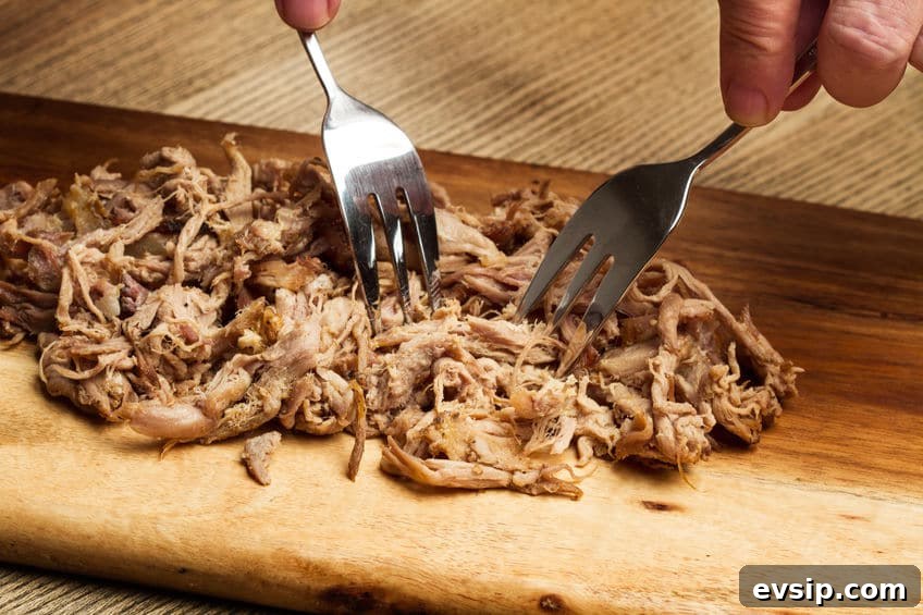 two forks, shredding pork into pieces © merazul via 123rf.com