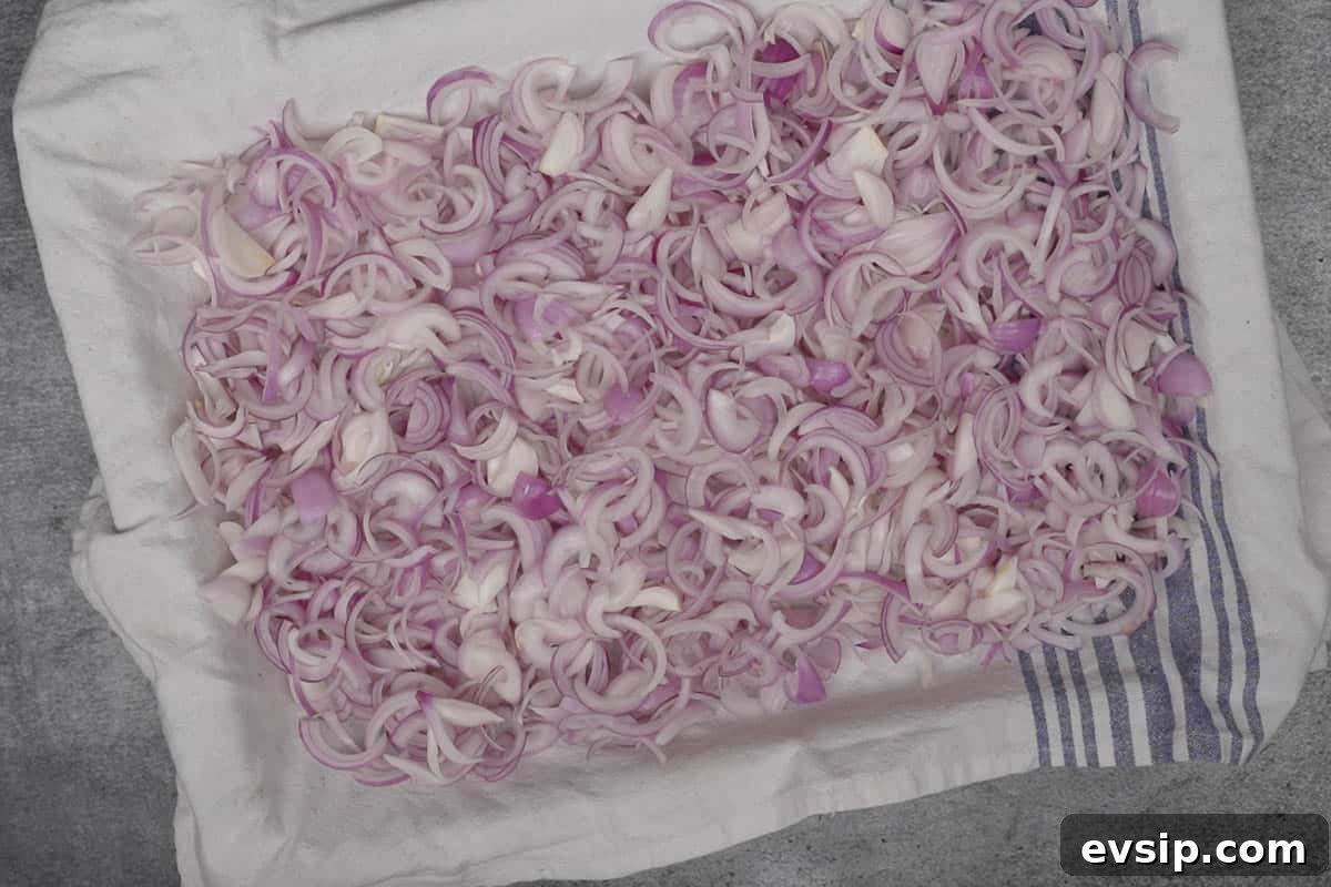 Onion slices spread on a kitchen cloth.