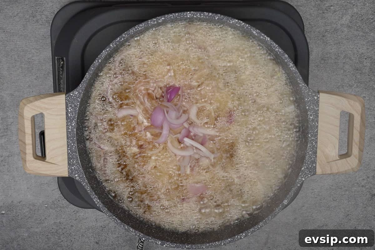 Onion slices added to hot oil.