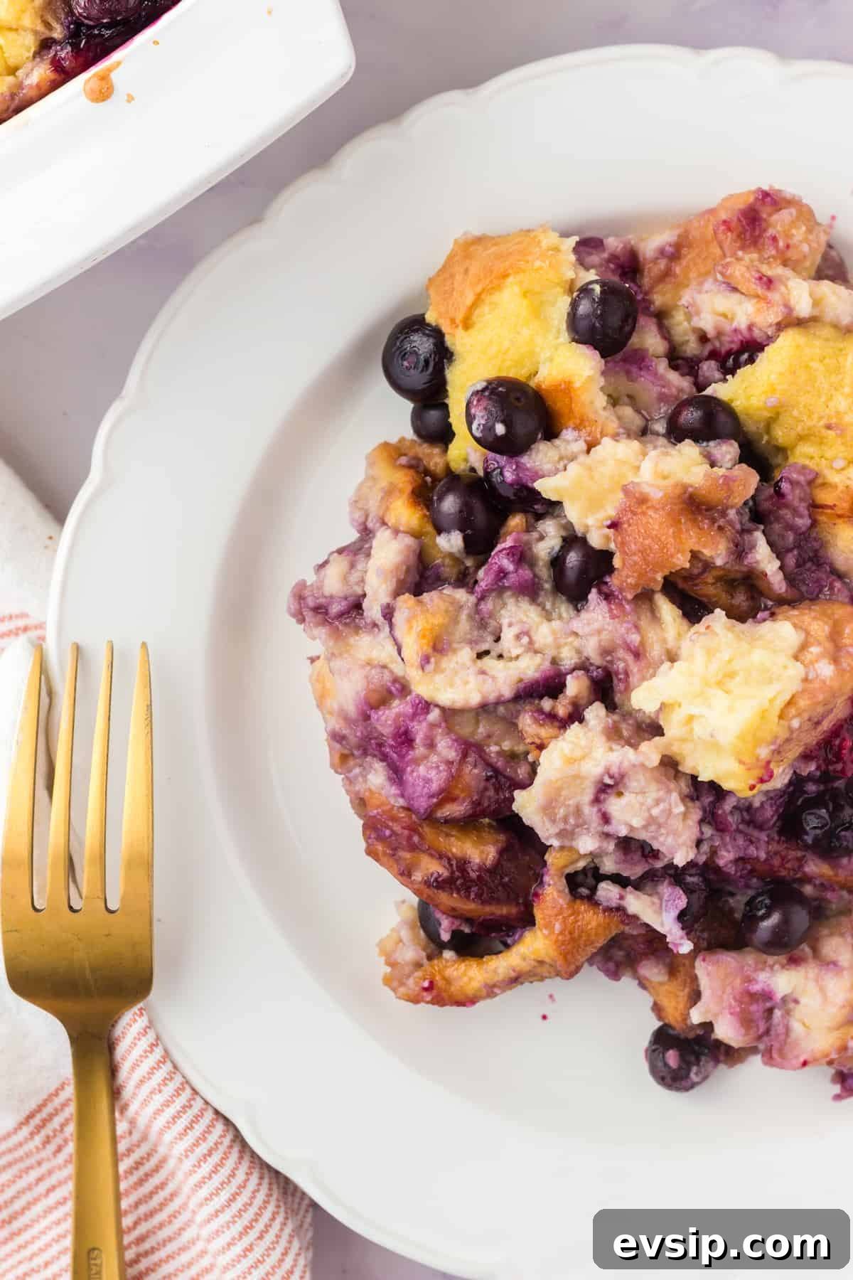 Lemon Blueberry Bread Pudding Recipe 3 Blueberry lemon bread pudding scooped onto a plate.