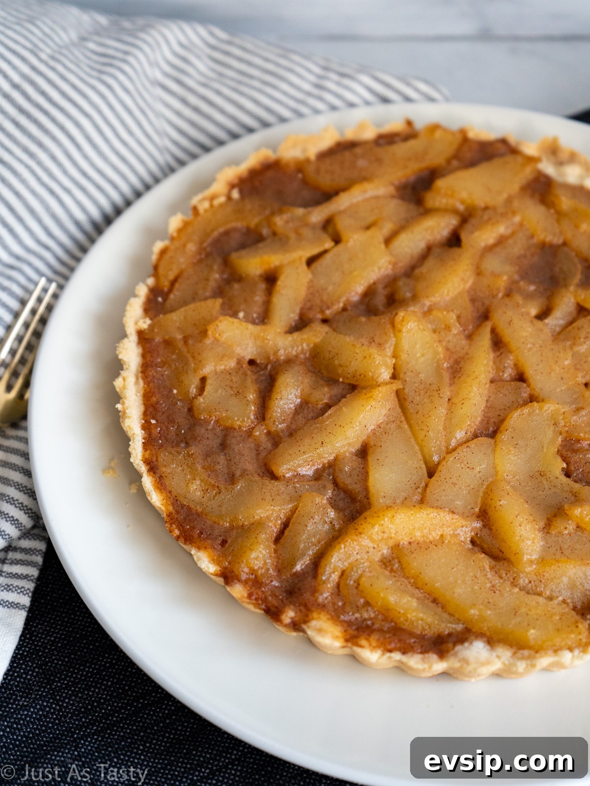 Caramel pear tart on a white plate.
