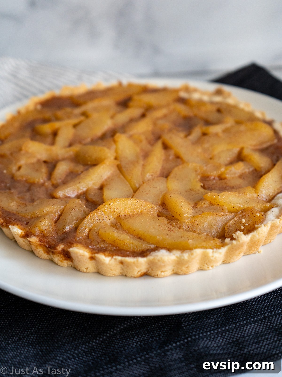 Close-up of a pear tart on a white plate.