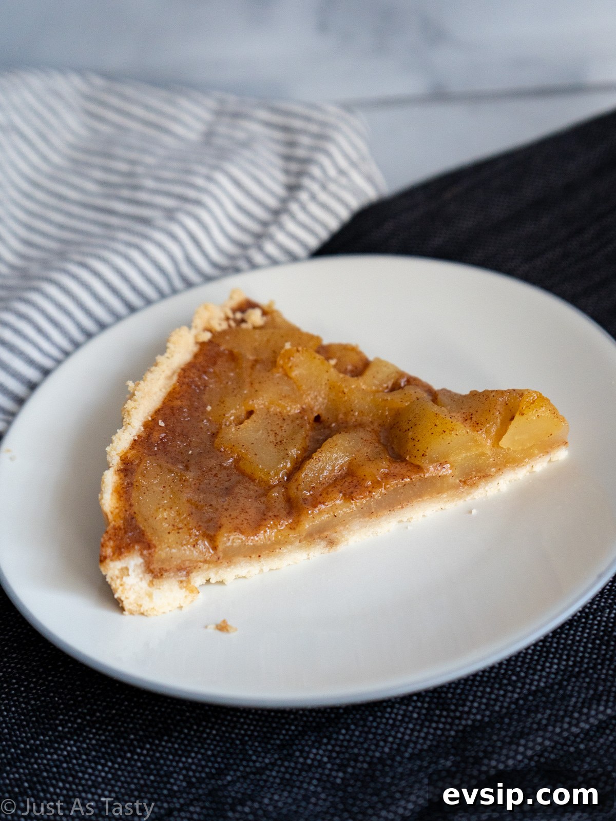 Slice of pear tart on a white plate.