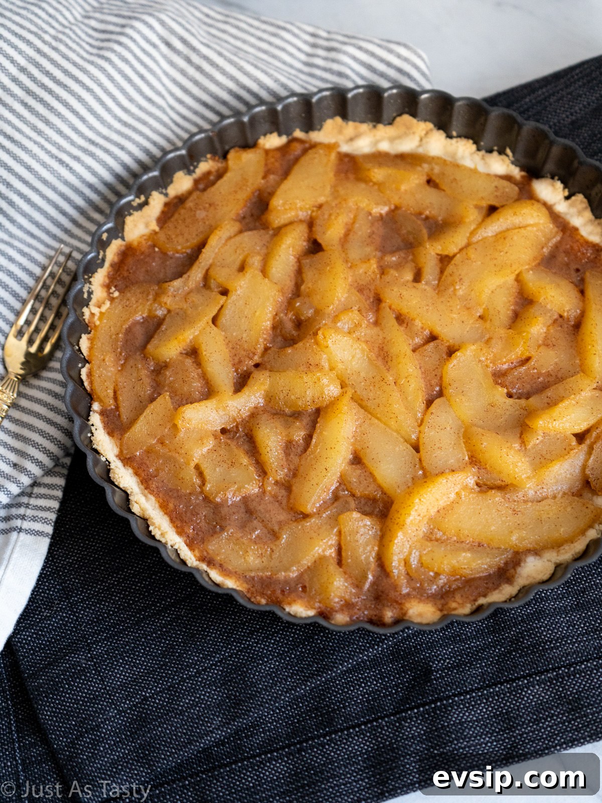 Pear tart in a black tart pan.